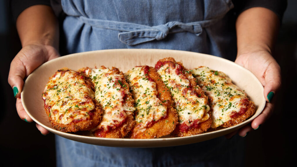Chicken Parmigiana : four pieces of tender brined and fried panko breaded chicken, topped with marinara sauce, mozzarella and pecorino