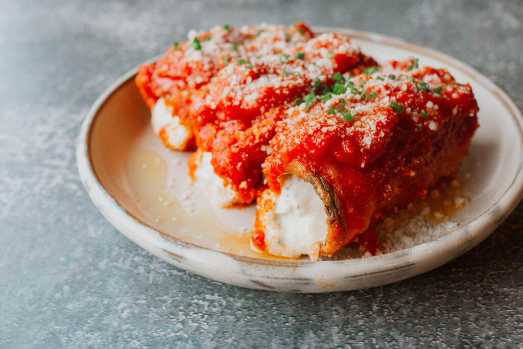 Eggplant Rollatini : battered and fried thinly sliced eggplant, stuffed with ricotta and mozzarella, and baked in out marinara sauce